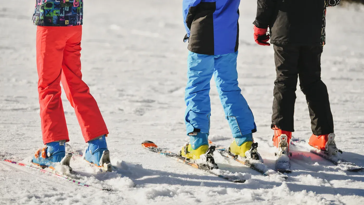 Barn och vuxna står på skidor i snön
