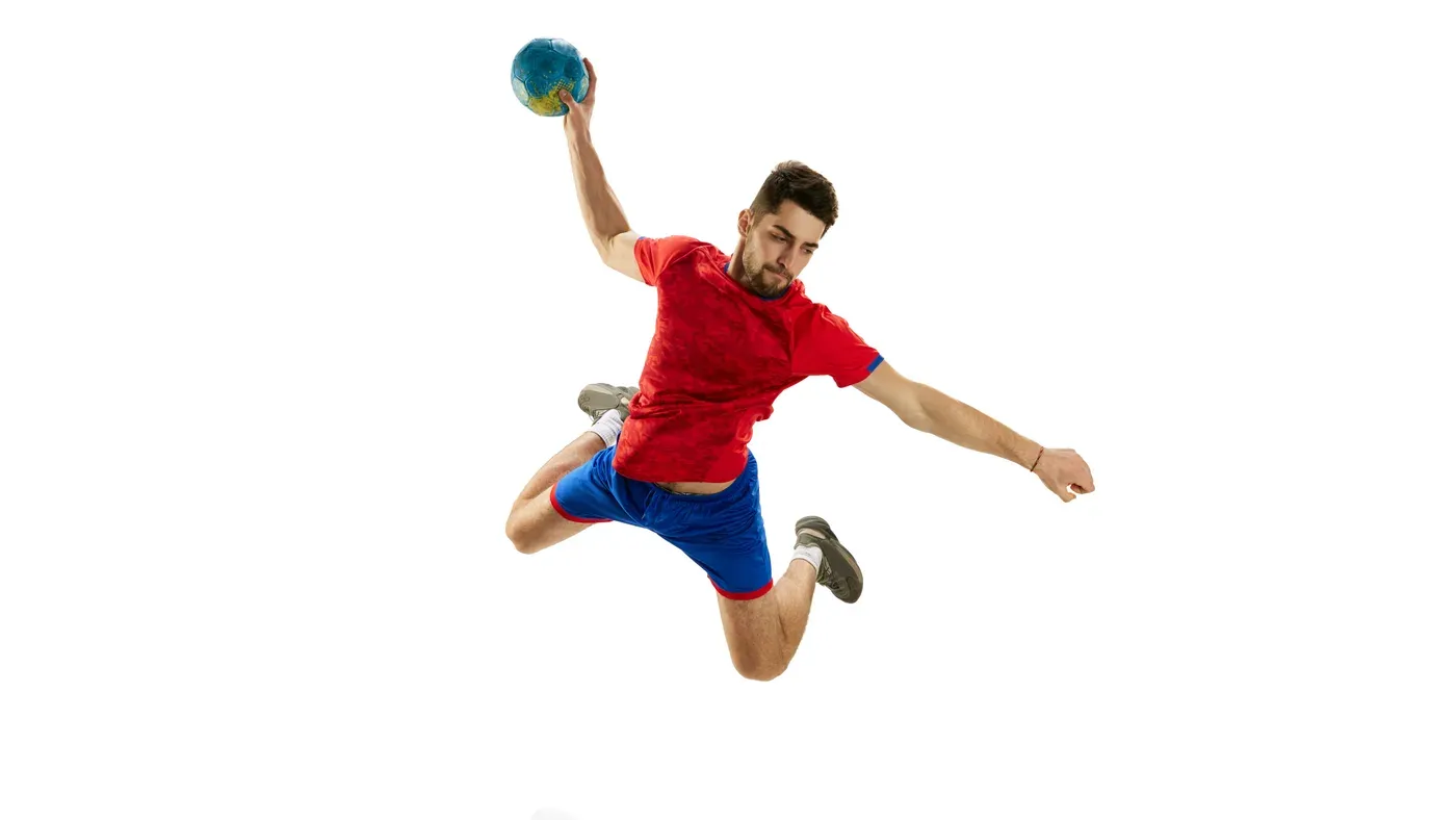 Handbollsspelare hoppar upp för skott med bollen i handen